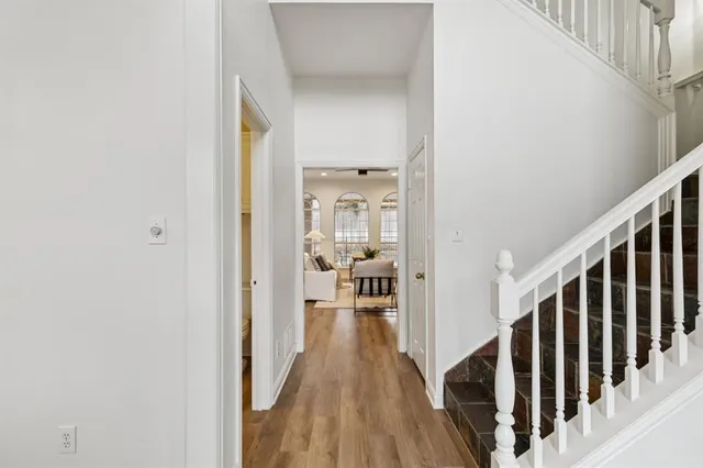 a view of a hallway with wooden floor and staircase