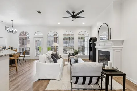 a living room with furniture fireplace and wooden floor