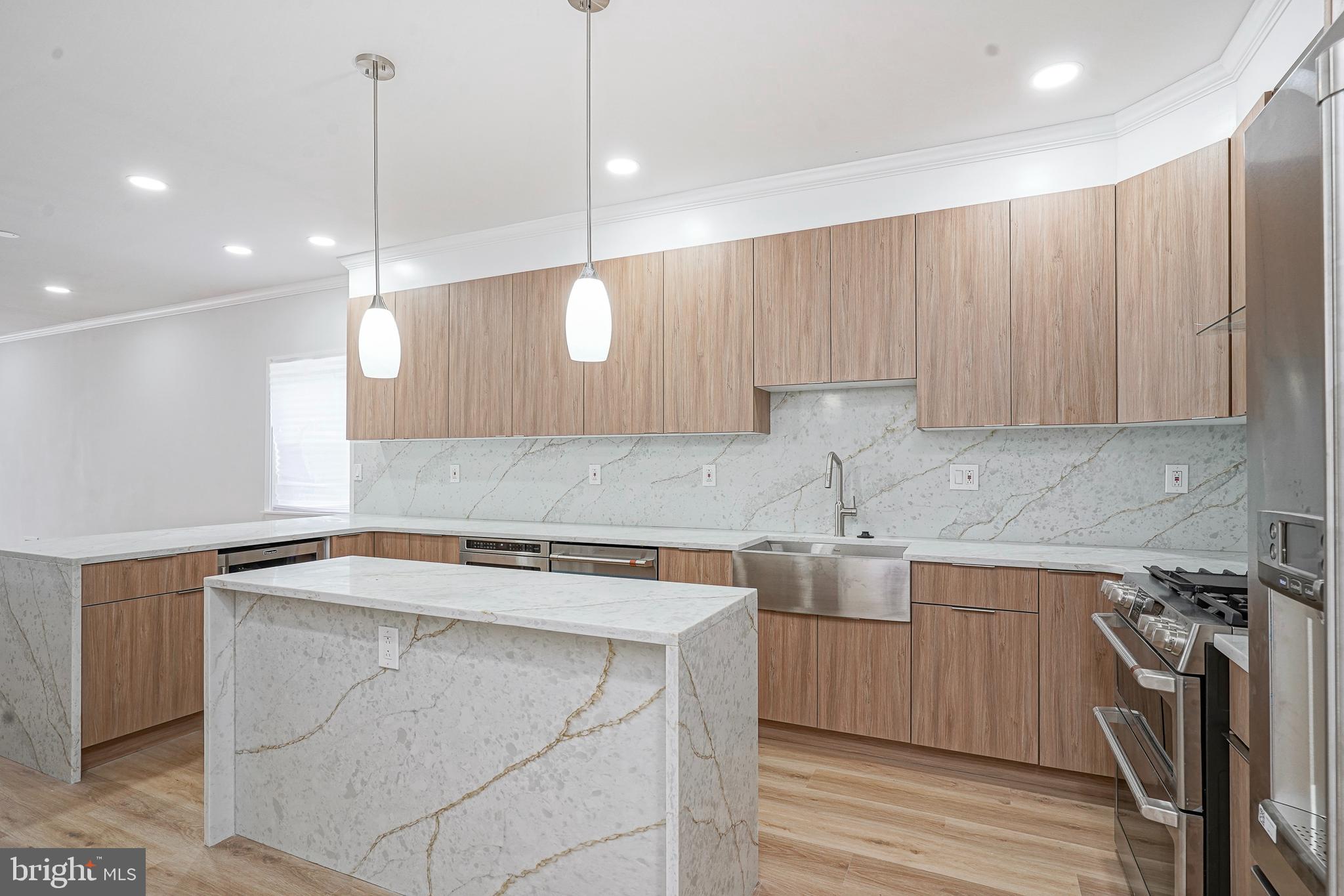 1145 Tasker Street Philadelphia, PA 19148 - Photo 11 of 58 a kitchen with a sink a cabinets and wooden floor