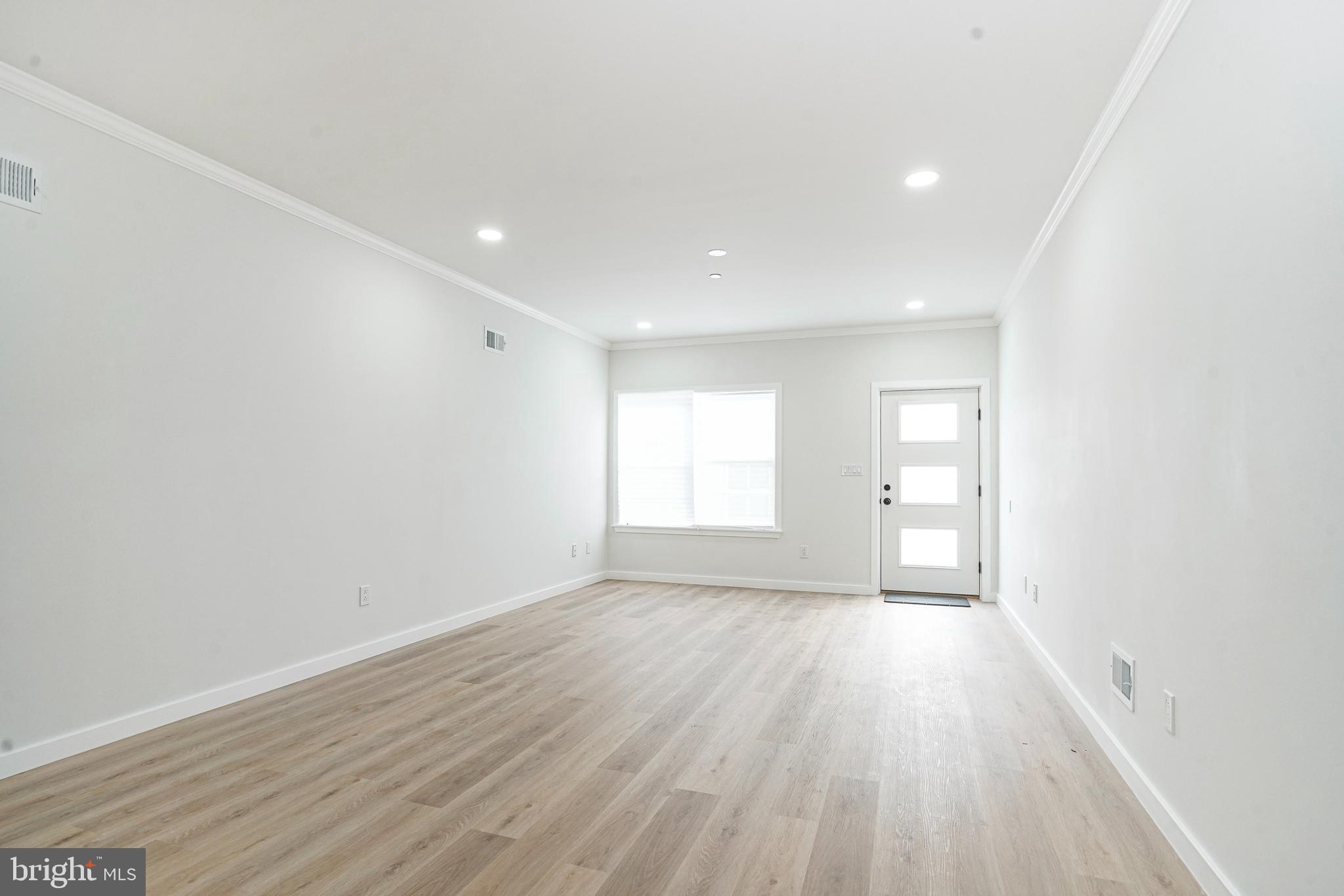 1145 Tasker Street Philadelphia, PA 19148 - Photo 5 of 58 a view of an empty room with wooden floor and a window