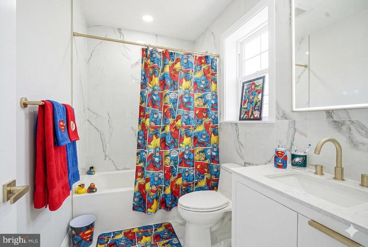 1145 Tasker Street Philadelphia, PA 19148 - Photo 55 of 58 a bathroom with a sink a toilet and a shower curtain