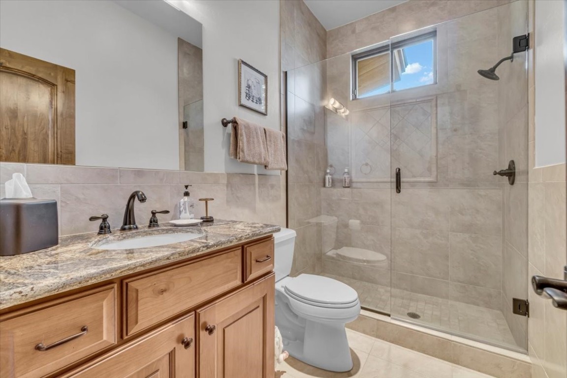 73 Last Chance Lane Dillon, CO 80435 - Photo 35 of 46 a bathroom with a granite countertop sink a toilet and shower