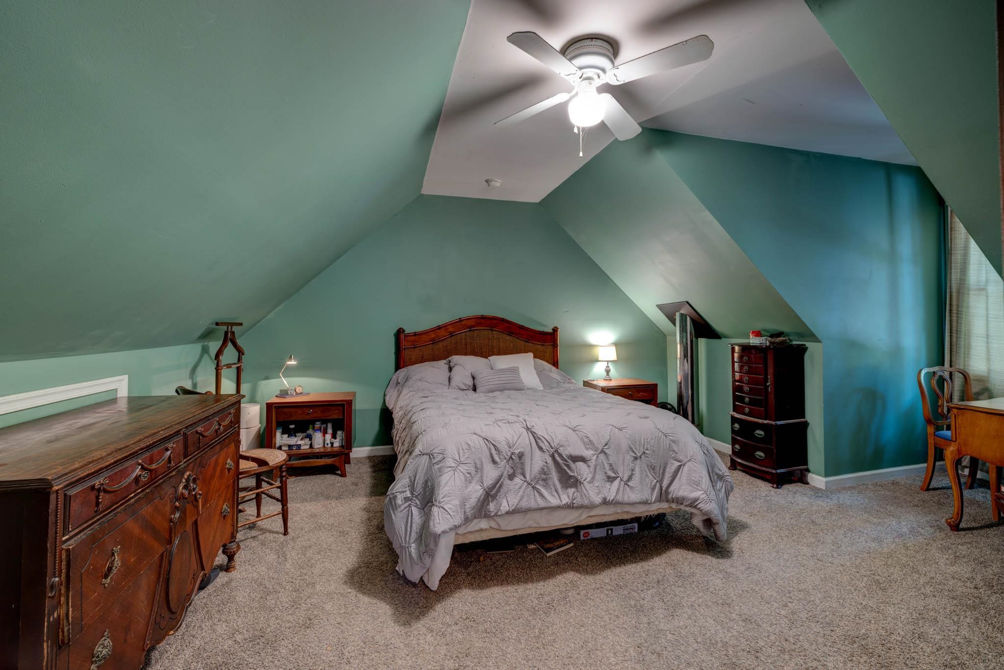 106 Delair Road Cape May, NJ 08204 - Photo 14 of 28 a spacious bedroom with a bed and a chandelier
