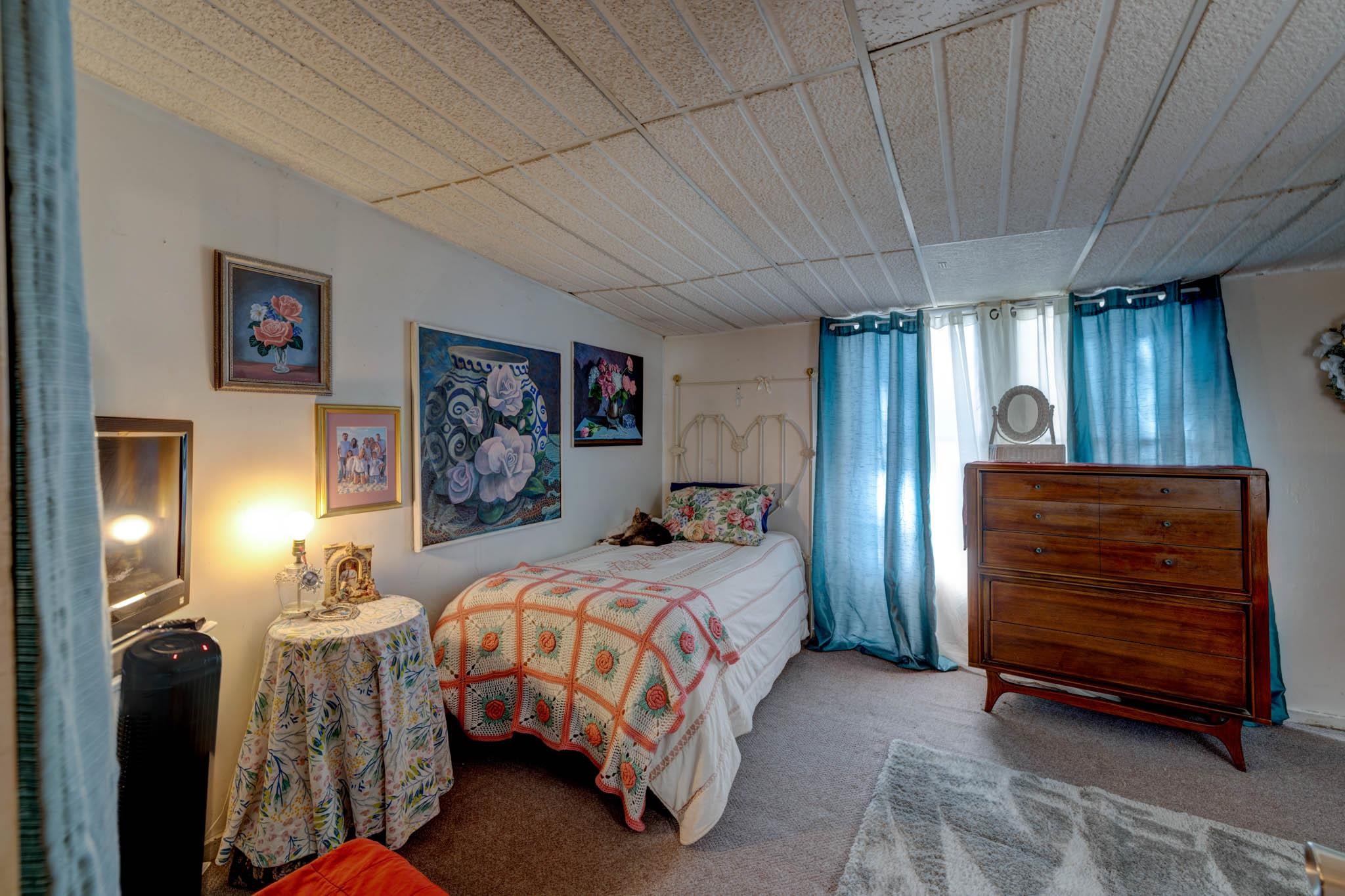 106 Delair Road Cape May, NJ 08204 - Photo 20 of 28 a bedroom with a bed and a chandelier