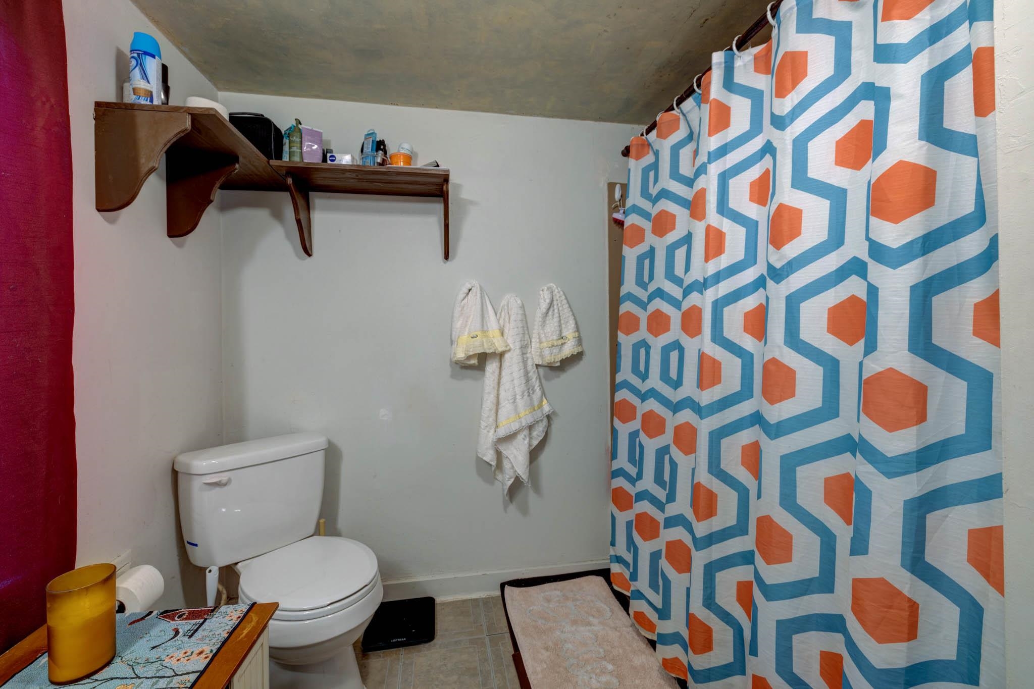 106 Delair Road Cape May, NJ 08204 - Photo 24 of 28 a white toilet sitting next to a shower curtain