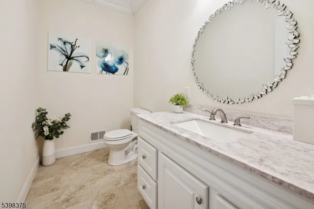 a bathroom with a granite countertop sink a toilet and a mirror