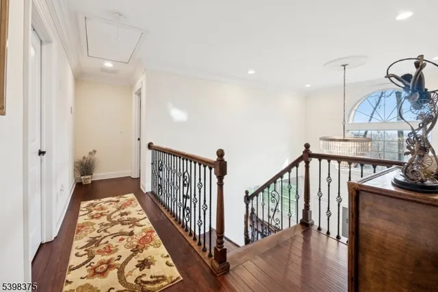 a view of a hallway with wooden floor and stairs
