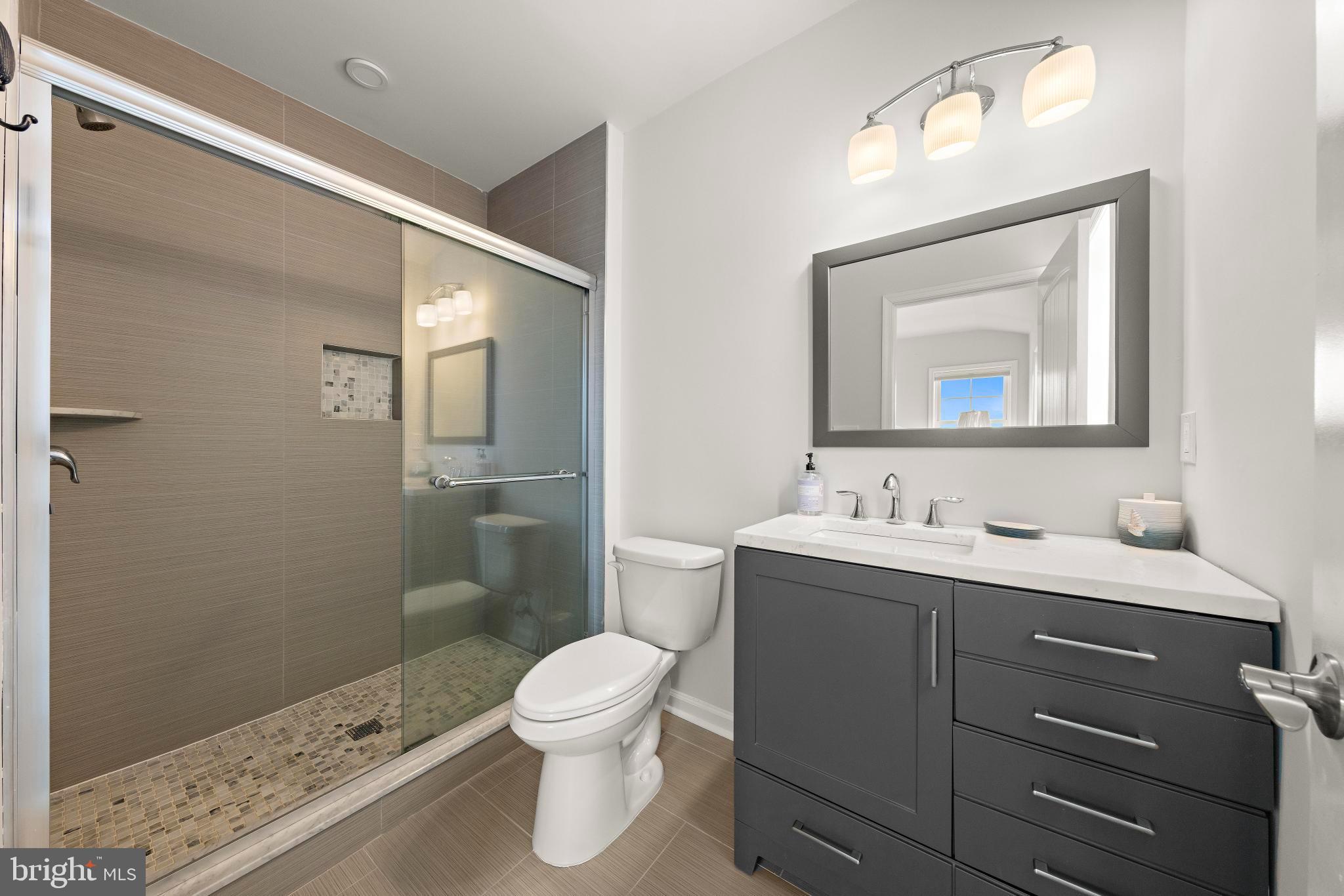 106 West 26th Street Ship Bottom, NJ 08008 - Photo 11 of 15 a bathroom with a toilet a sink and mirror