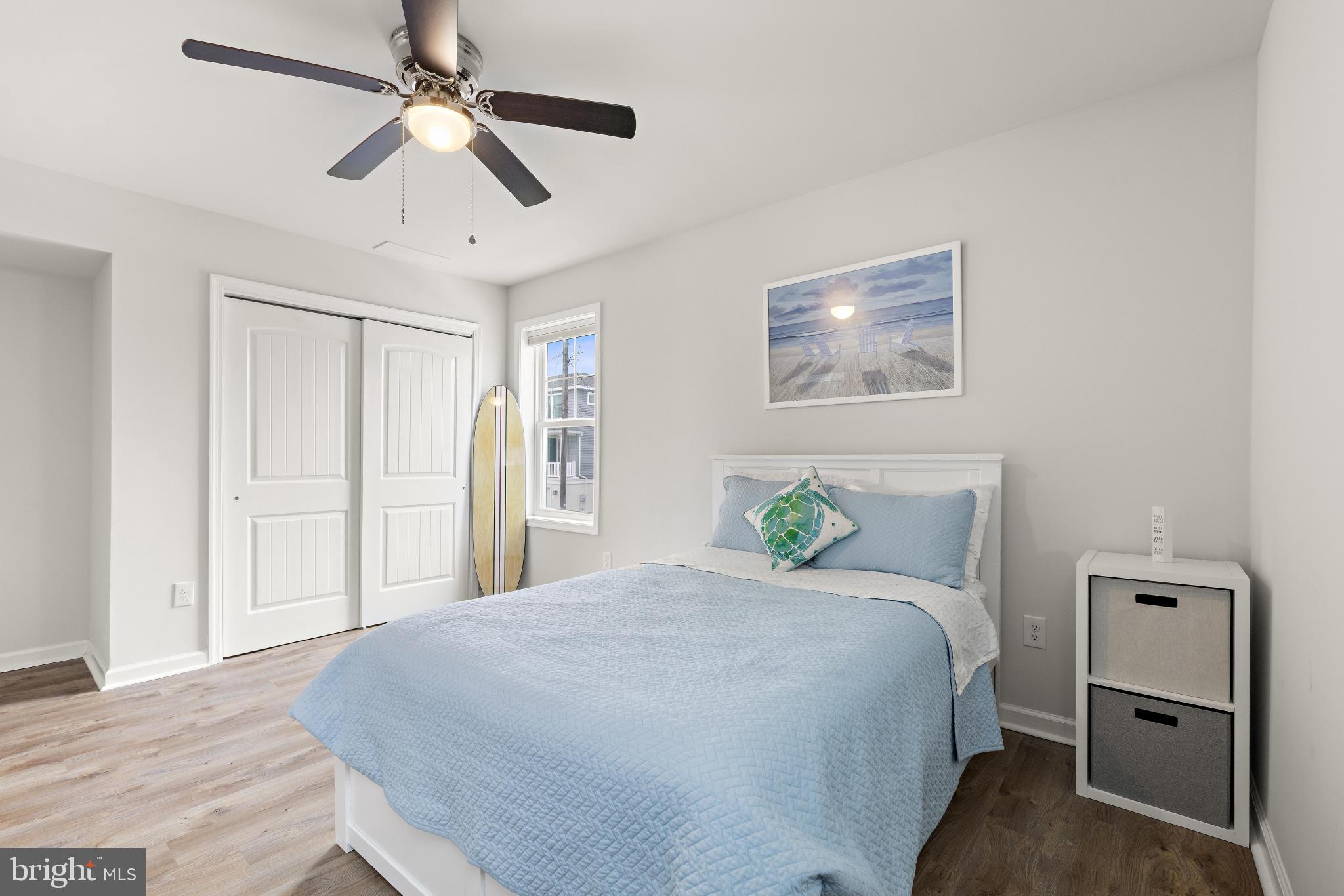 106 West 26th Street Ship Bottom, NJ 08008 - Photo 12 of 15 a bedroom with a large bed and a chandelier