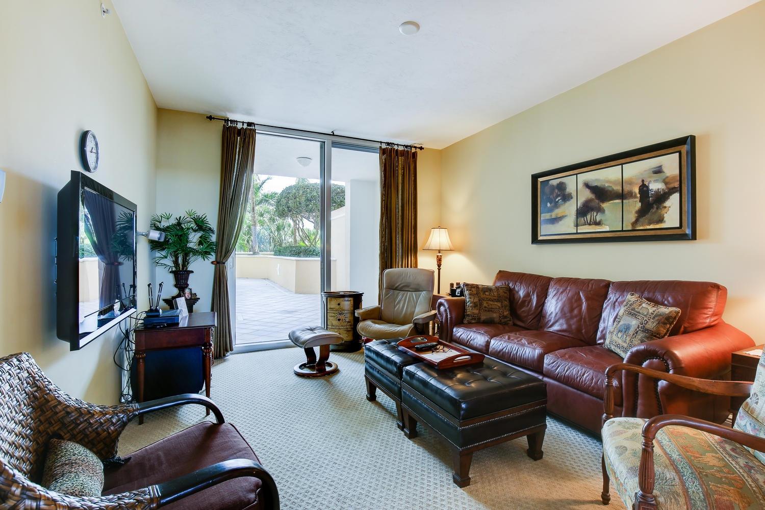 700 Highway 1, Unit 103 Jupiter, FL 33477 - Photo 11 of 36 a living room with furniture a flat screen tv and a large window