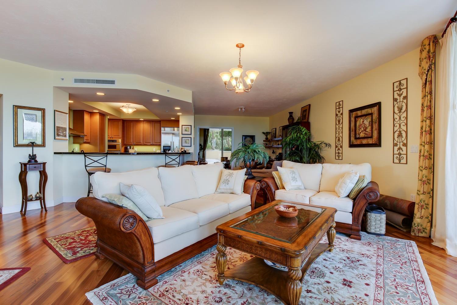 700 Highway 1, Unit 103 Jupiter, FL 33477 - Photo 8 of 36 a living room with furniture a rug and a chandelier