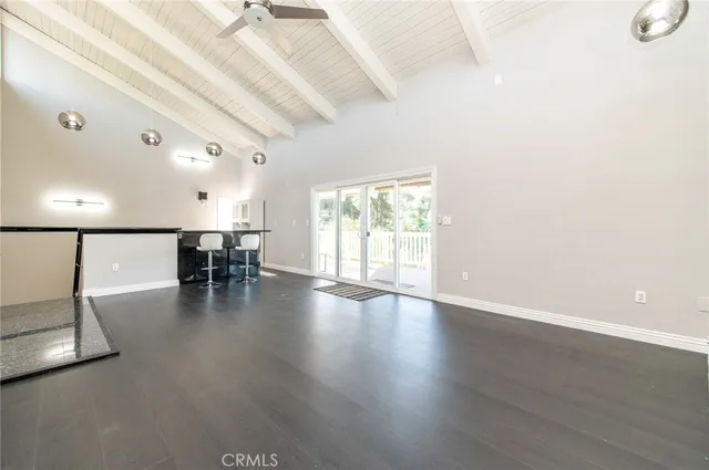 a view of a bedroom with a bed and wooden floor