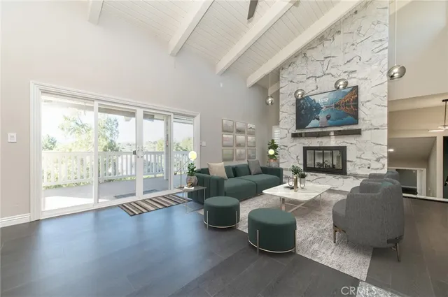 a living room with furniture a fireplace and a floor to ceiling window