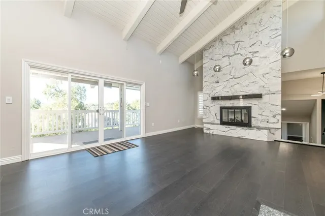 wooden floor fireplace and windows in an empty room