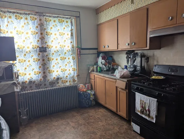 a kitchen with stainless steel appliances wooden cabinets and a stove top oven