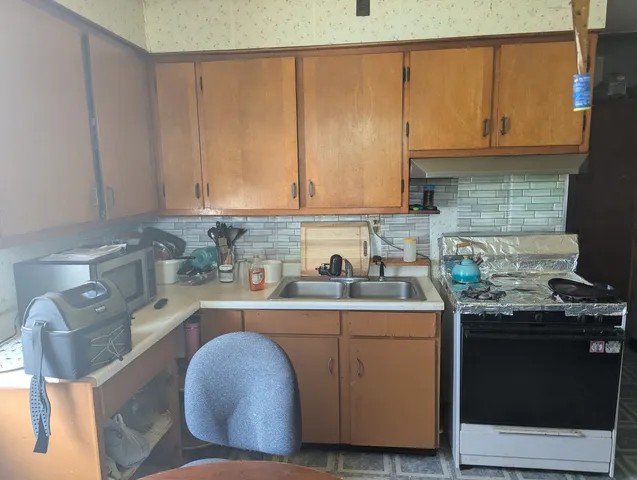 a kitchen with stainless steel appliances granite countertop a sink a stove and a microwave