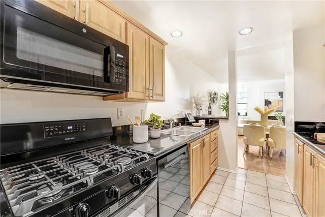 a kitchen with stainless steel appliances granite countertop a sink a stove a refrigerator and cabinets