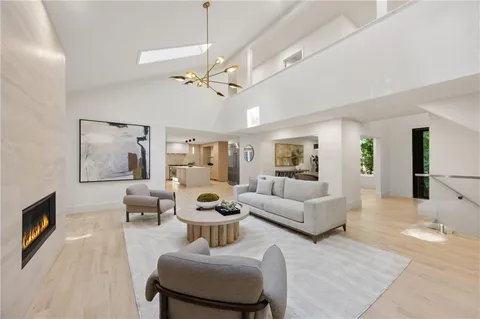 a living room with furniture a chandelier and a glass door