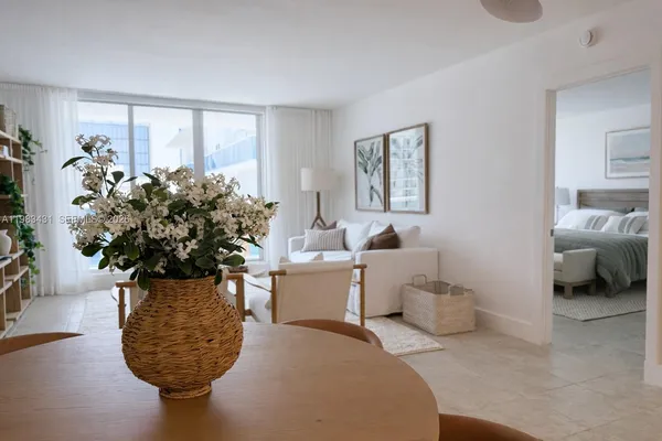 a living room with furniture a potted plant and a window