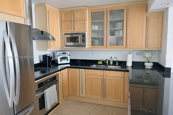 a kitchen with stainless steel appliances granite countertop a refrigerator and a sink