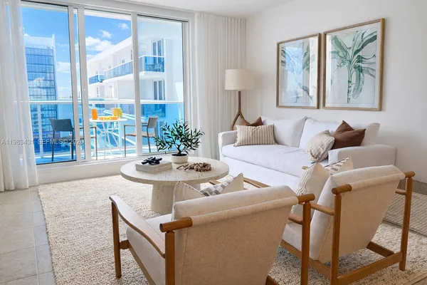 a living room with furniture and a painting on the wall