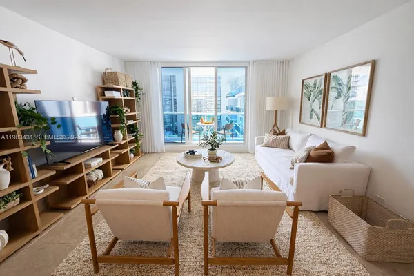 a view of a dining room with furniture a rug and wooden floor
