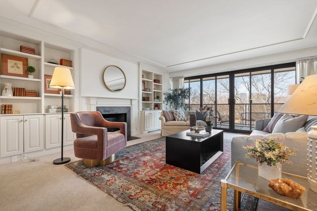a living room with furniture a fireplace and a large window