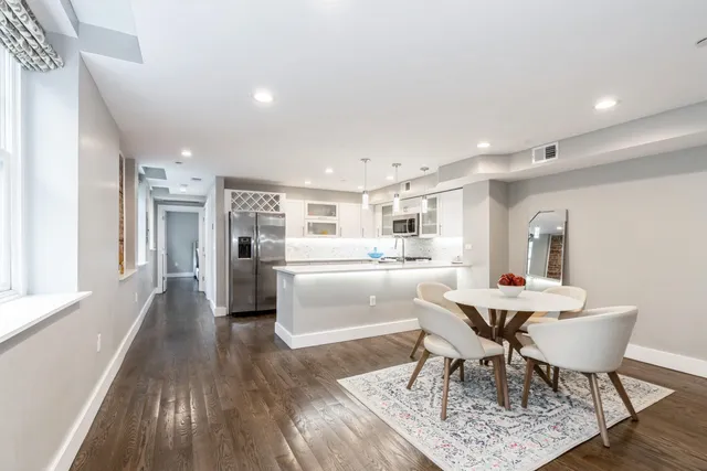 a kitchen with a dining table chairs and refrigerator