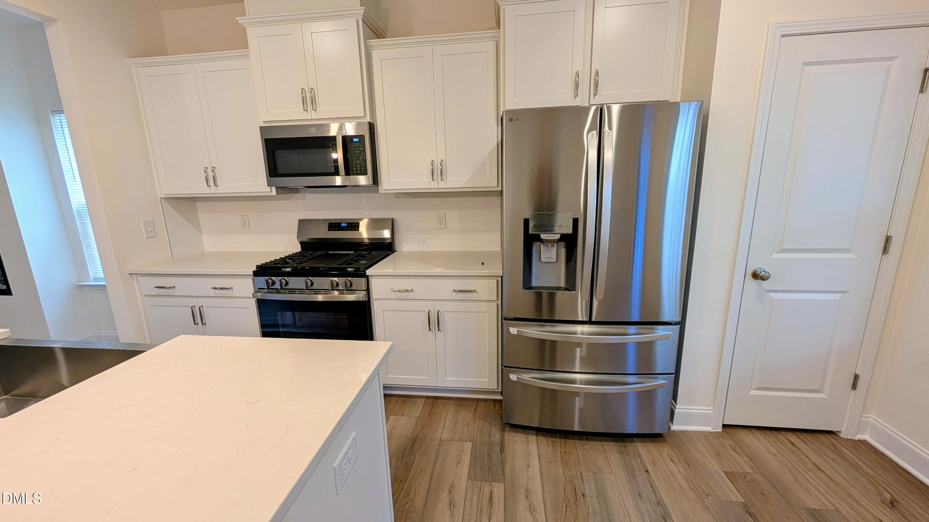 1003 Shovelhead Drive Durham, NC 27703 - Photo 3 of 21 a kitchen with stainless steel appliances wooden floor sink and microwave