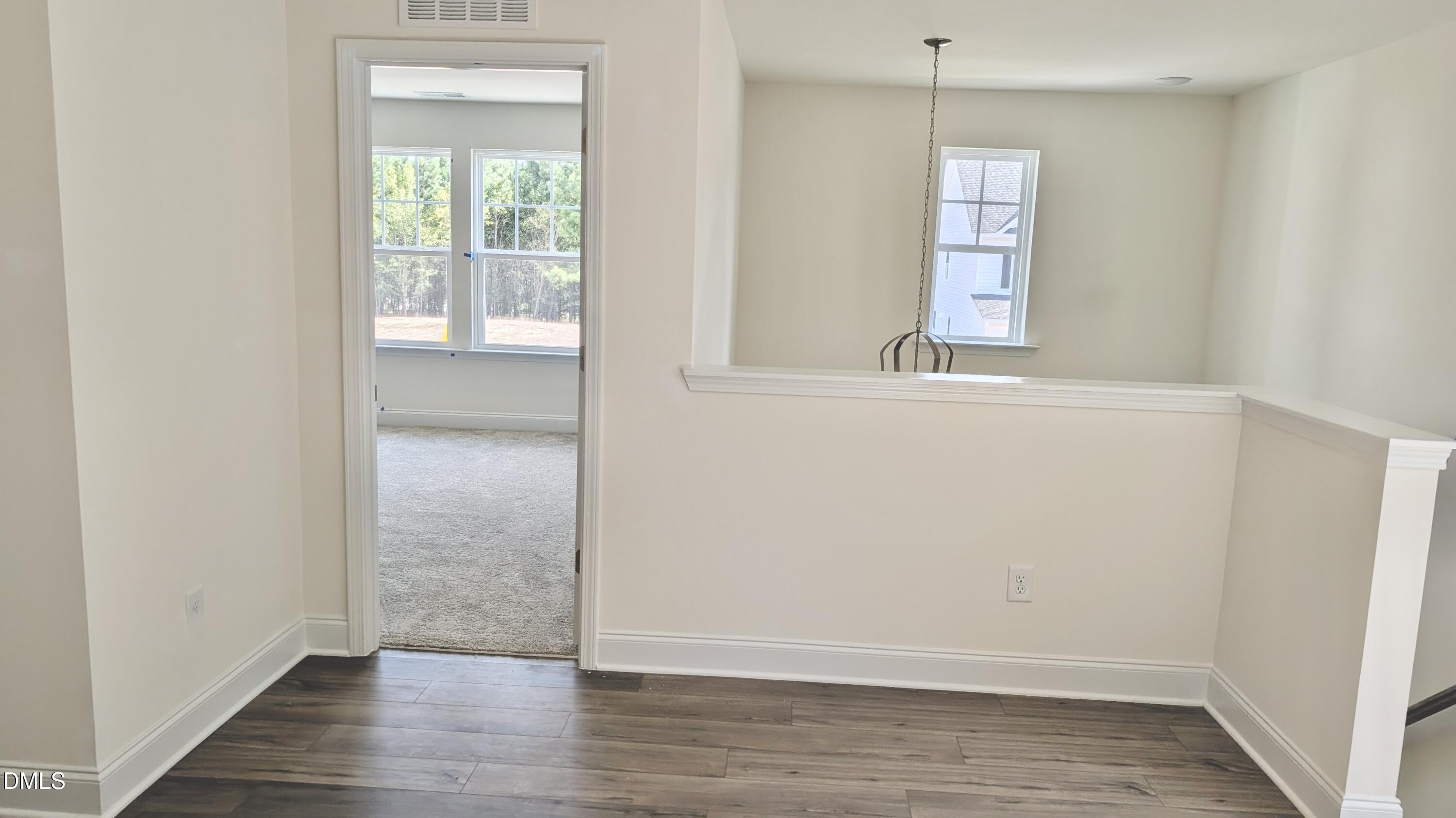 1003 Shovelhead Drive Durham, NC 27703 - Photo 7 of 21 a view of an empty room with wooden floor and a window
