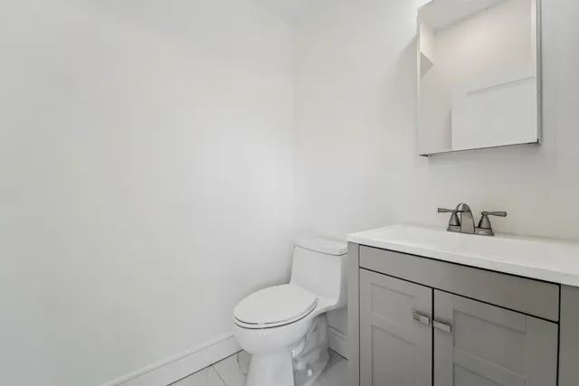 a bathroom with a toilet sink vanity and granite