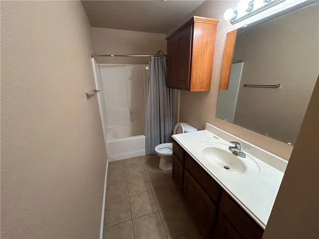 a bathroom with a sink a toilet a mirror and shower