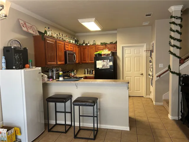 a kitchen with refrigerator and cabinets