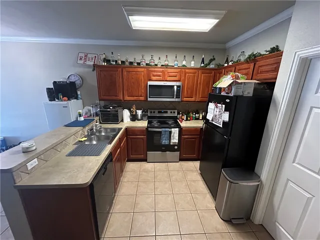 a kitchen with a sink stainless steel appliances a counter top space and cabinets