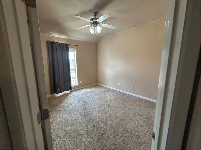a view of an empty room with a ceiling fan