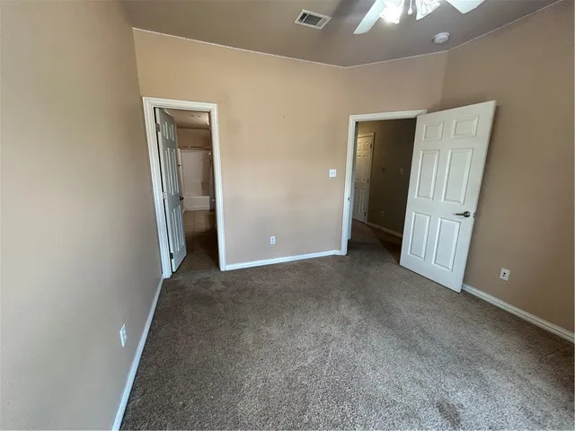 an empty room with closet and a chandelier fan