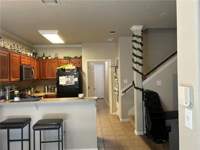 a kitchen with stainless steel appliances kitchen island granite countertop a refrigerator and a sink