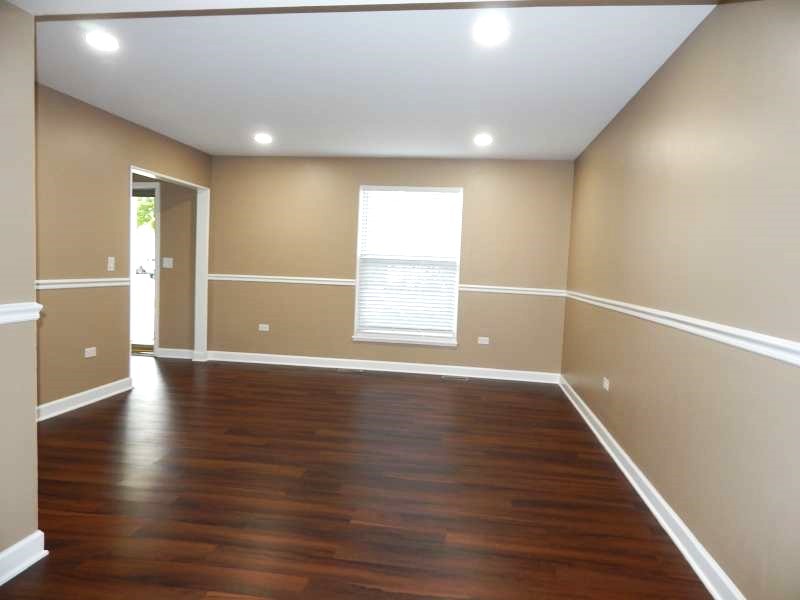 1216 Calico Avenue Naperville, IL 60564 - Photo 2 of 16 a view of an empty room with wooden floor and a window