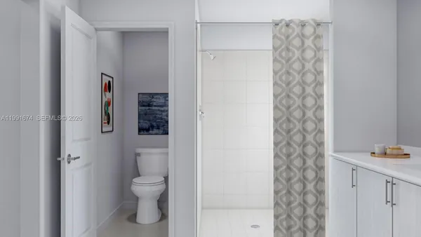 a bathroom with a toilet and a shower curtain