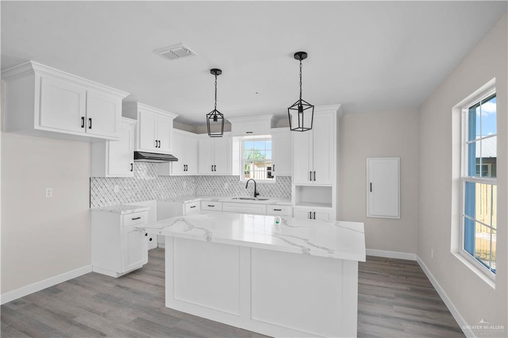 1343 Middle Street Alamo, TX 78516 - Photo 5 of 17 a large white kitchen with granite countertop a sink a window and stainless steel appliances