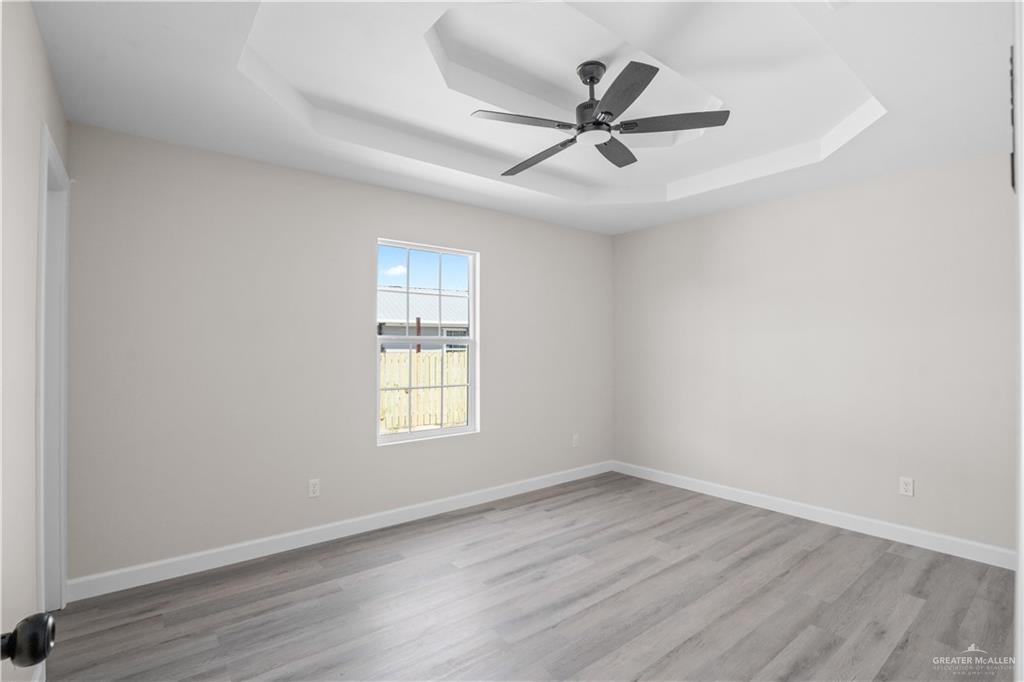 1343 Middle Street Alamo, TX 78516 - Photo 7 of 17 an empty room with wooden floor fan and windows