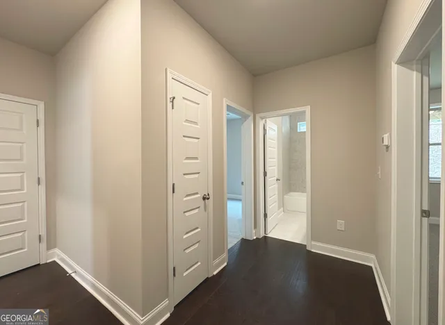 an empty room with wooden floor cabinet and windows