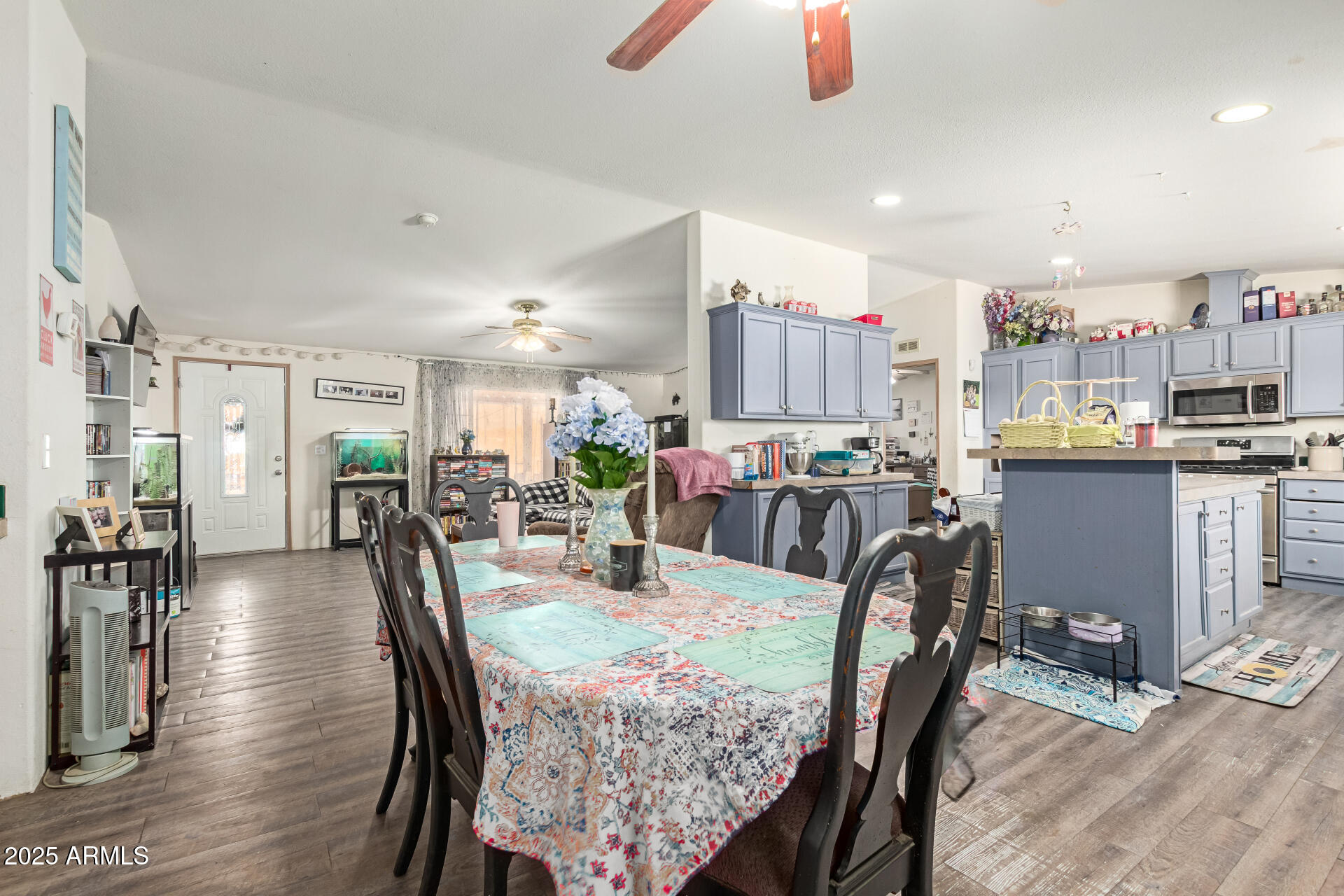 1347 South Oak Road Maricopa, AZ 85139 - Photo 9 of 30 a view of a dining room and livingroom with furniture wooden floor a rug a painting