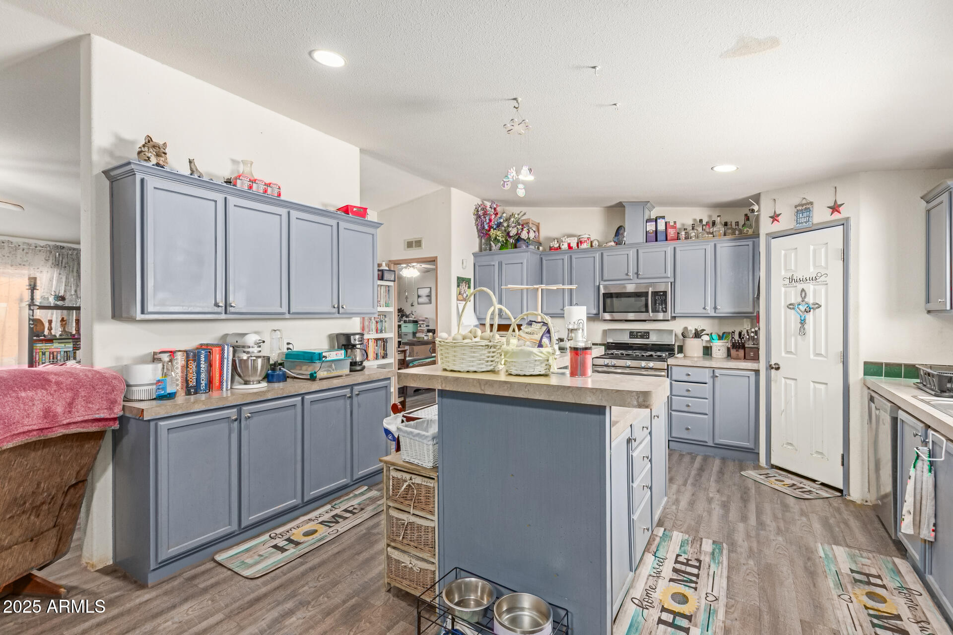 1347 South Oak Road Maricopa, AZ 85139 - Photo 10 of 30 a kitchen with kitchen island a sink cabinets and wooden floor
