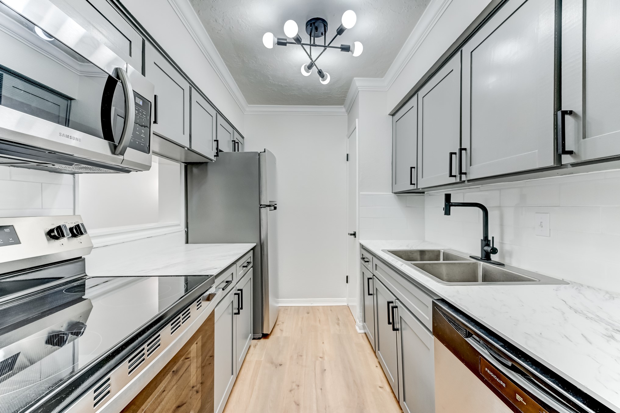 3224 Timmons Lane, Unit 157 Houston, TX 77027 - Photo 13 of 30 a kitchen with stainless steel appliances sink a stove and cabinets