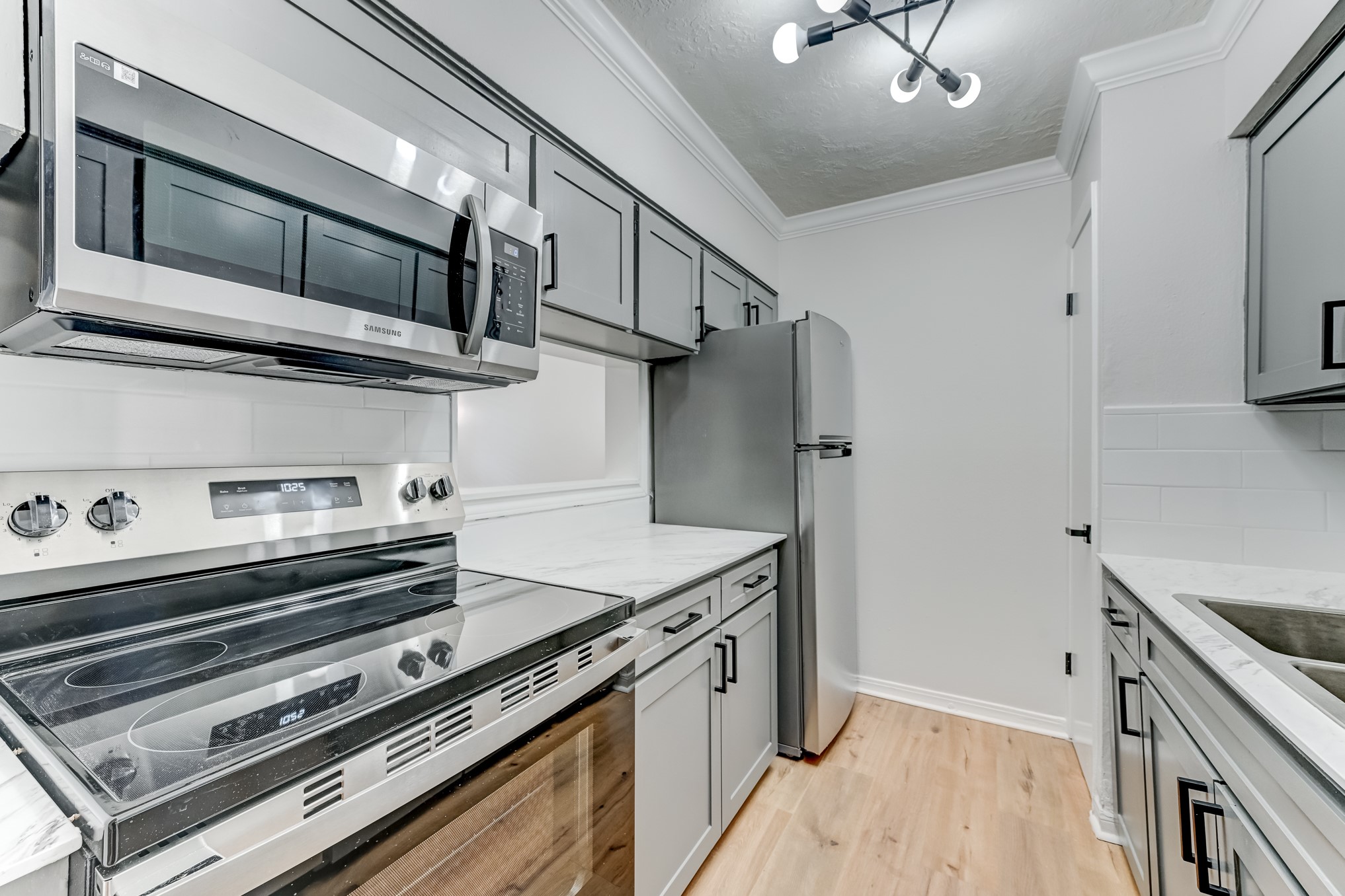 3224 Timmons Lane, Unit 157 Houston, TX 77027 - Photo 14 of 30 a kitchen with stainless steel appliances granite countertop a stove and a microwave