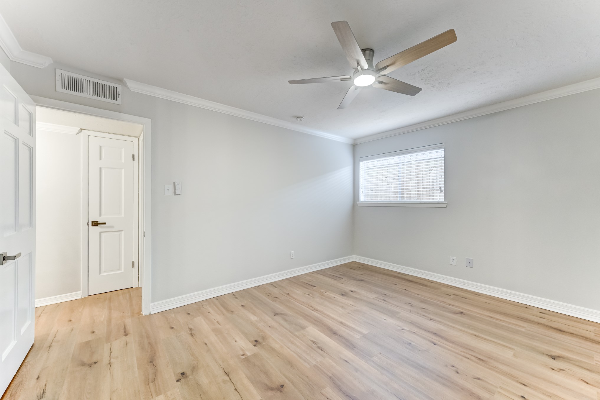 3224 Timmons Lane, Unit 157 Houston, TX 77027 - Photo 21 of 30 a view of an empty room with wooden floor and a ceiling fan