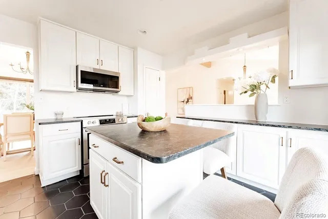 a kitchen with stainless steel appliances granite countertop a sink a stove and a microwave