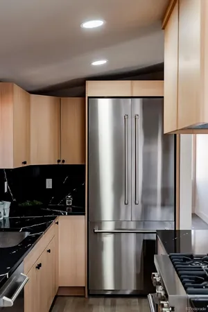 a kitchen with stainless steel appliances granite countertop a refrigerator and a stove top oven