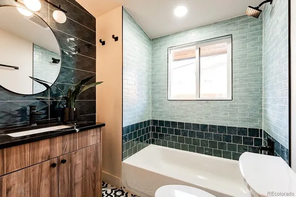 a bathroom with a sink a toilet a mirror and shower